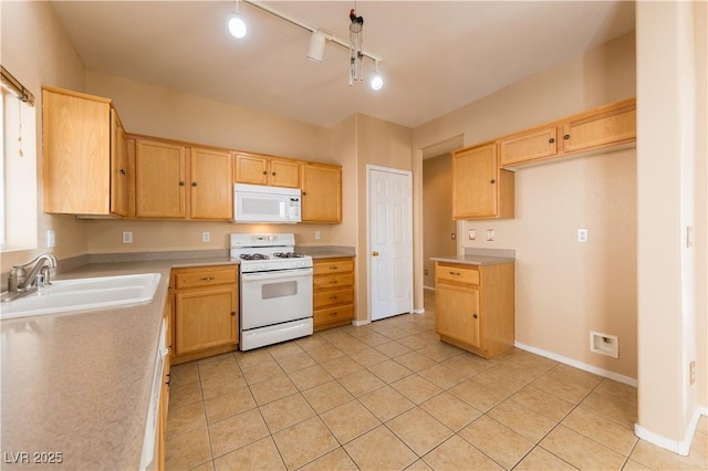 kitchen with white appliances, light tile patterned floors, sink, and light brown cabinets