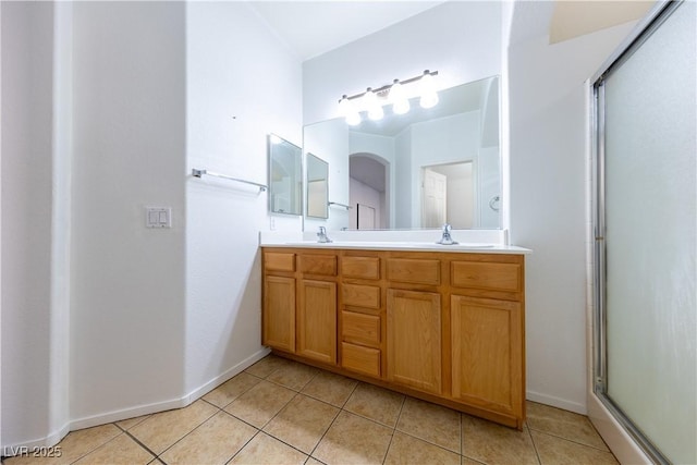 bathroom with tile patterned flooring, vanity, and a shower with door