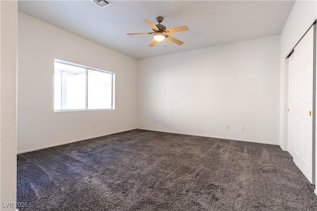 interior space featuring ceiling fan and dark carpet