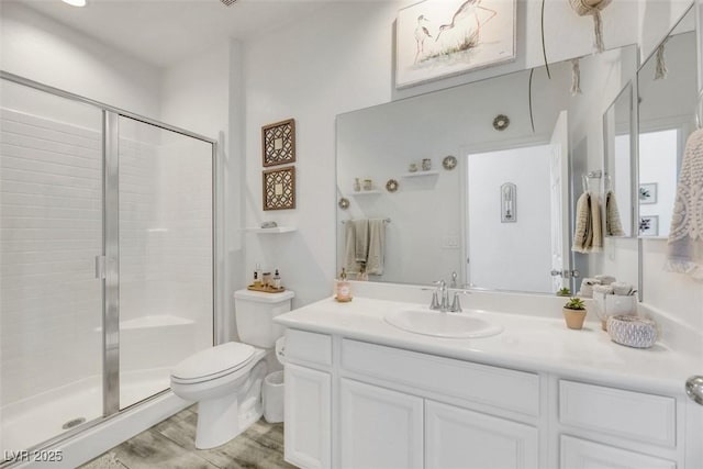 bathroom with vanity, wood-type flooring, an enclosed shower, and toilet