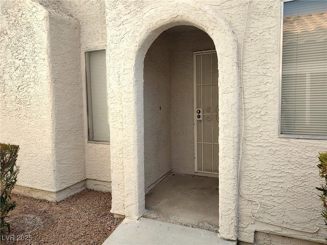 entrance to property featuring stucco siding