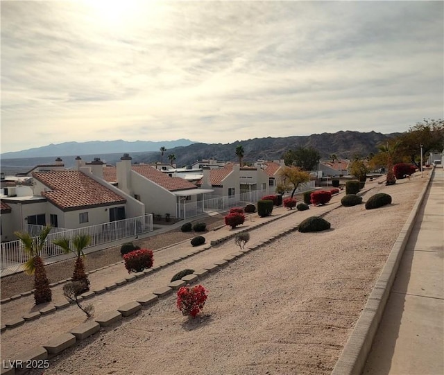 exterior space featuring a residential view, a mountain view, and fence