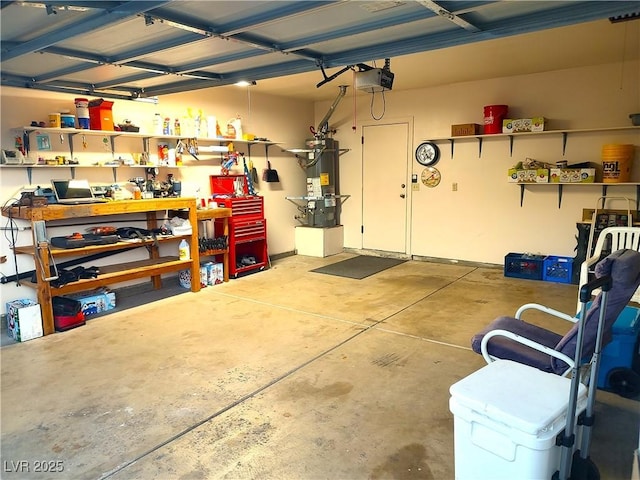 garage with a workshop area, a garage door opener, and water heater