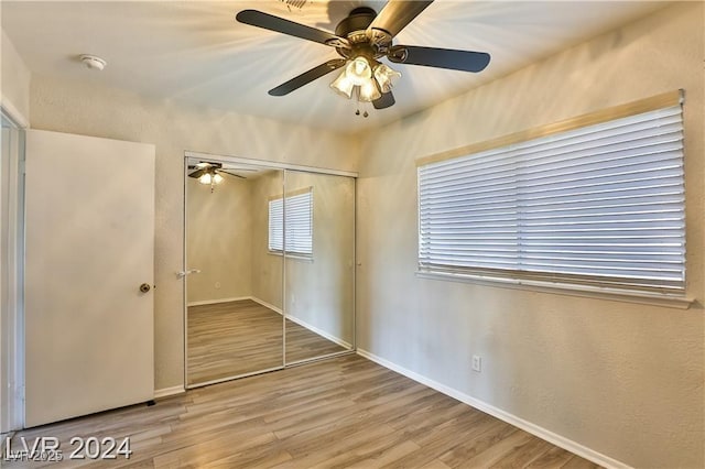 unfurnished bedroom with hardwood / wood-style flooring, ceiling fan, and a closet