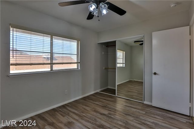 unfurnished bedroom featuring dark hardwood / wood-style floors, ceiling fan, and a closet