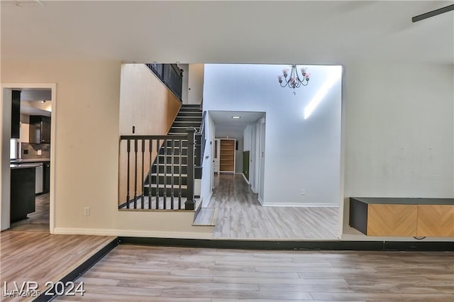 staircase with hardwood / wood-style flooring and an inviting chandelier