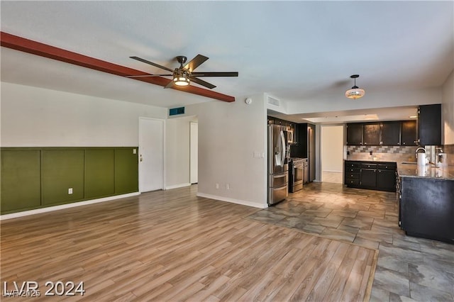 unfurnished living room featuring sink, light hardwood / wood-style flooring, beamed ceiling, and ceiling fan