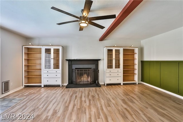 unfurnished living room with beamed ceiling, ceiling fan, and light hardwood / wood-style floors