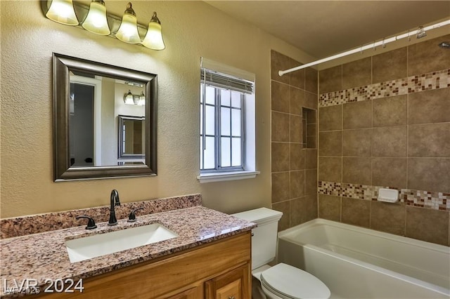 full bathroom with vanity, tiled shower / bath combo, and toilet