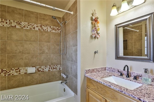 bathroom featuring tiled shower / bath combo and vanity