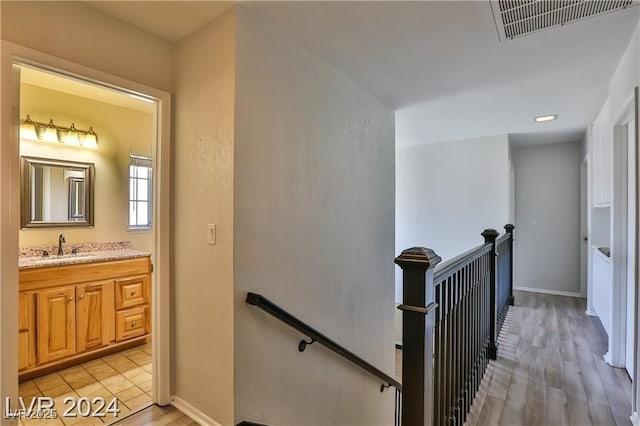 corridor featuring sink and light hardwood / wood-style floors