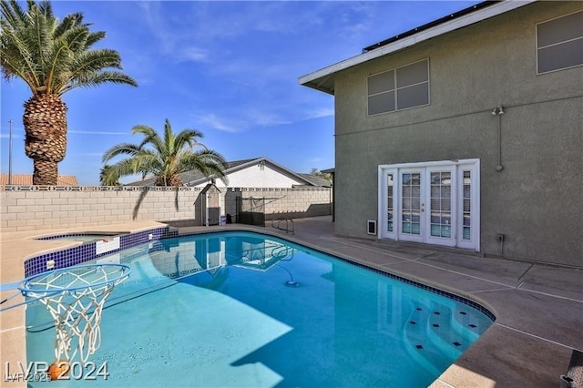 view of swimming pool with a patio, french doors, and an in ground hot tub