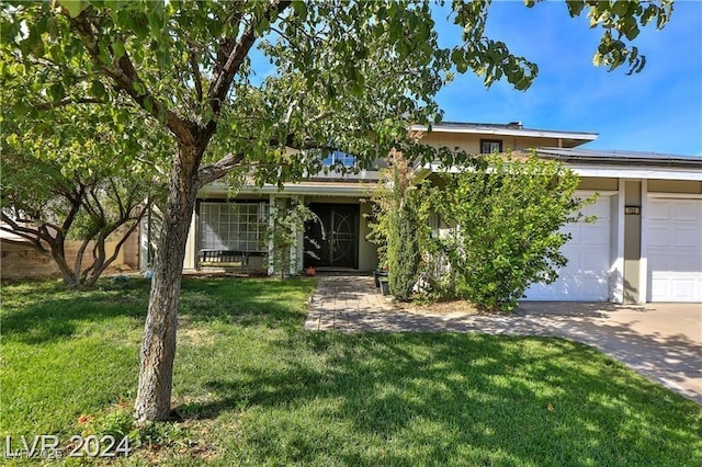 view of front of home with a garage and a front lawn