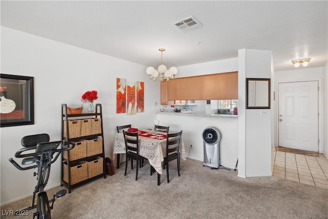 dining area featuring light carpet and an inviting chandelier