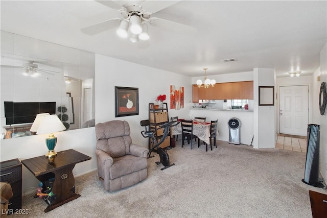 living room featuring light colored carpet and ceiling fan with notable chandelier