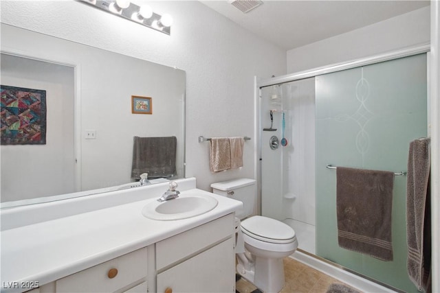 bathroom featuring vanity, toilet, and an enclosed shower