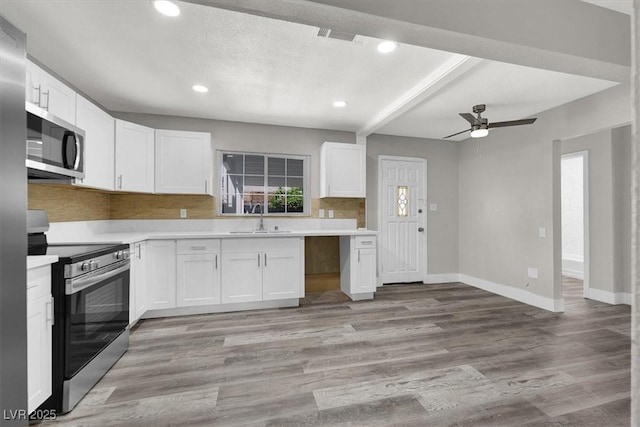 kitchen with sink, light hardwood / wood-style floors, white cabinets, and appliances with stainless steel finishes