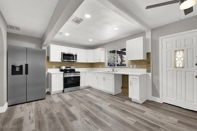 kitchen featuring white cabinetry, appliances with stainless steel finishes, sink, and light wood-type flooring