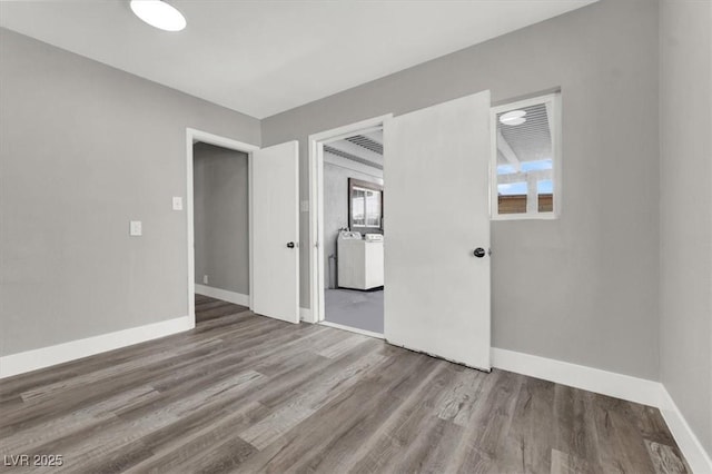 spare room featuring washer / dryer and wood-type flooring