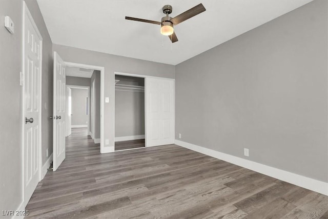 unfurnished bedroom featuring dark hardwood / wood-style flooring, a closet, and ceiling fan