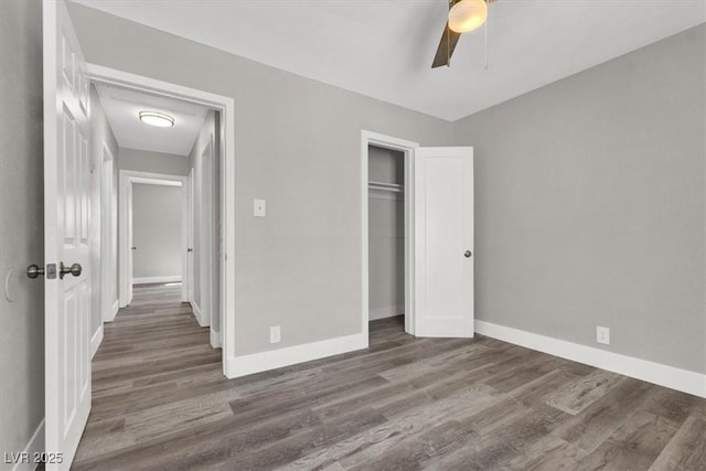 unfurnished bedroom featuring ceiling fan, dark hardwood / wood-style floors, and a closet