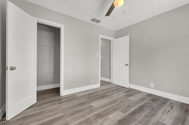 unfurnished bedroom featuring ceiling fan, a closet, and light wood-type flooring