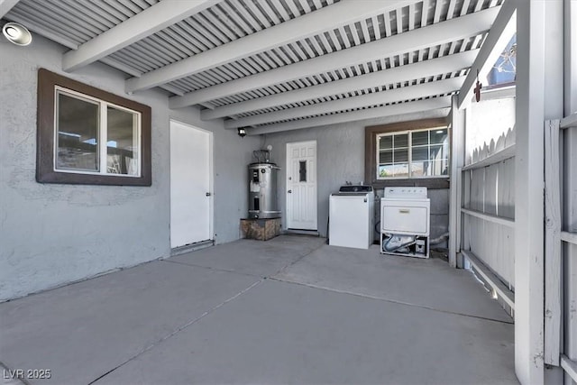 view of patio featuring separate washer and dryer and electric water heater