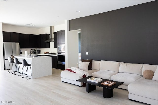 living room with sink and light hardwood / wood-style flooring