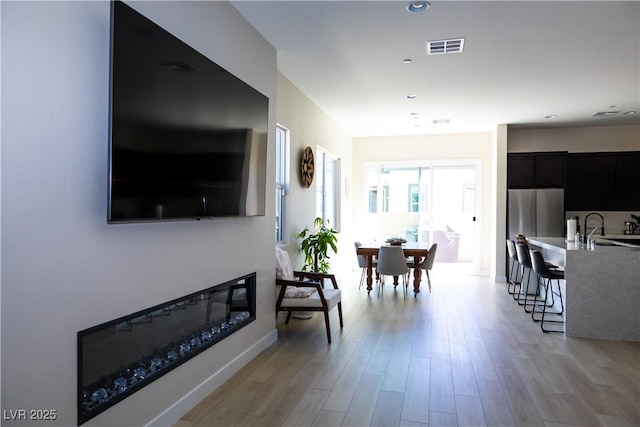 living room with sink and light hardwood / wood-style flooring