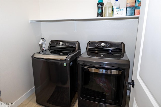 clothes washing area with washer and dryer and light wood-type flooring