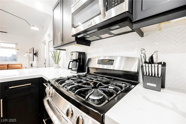 kitchen with stainless steel appliances, light stone counters, and decorative backsplash