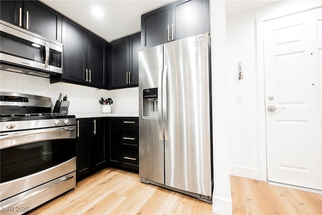 kitchen with backsplash, stainless steel appliances, and light hardwood / wood-style floors