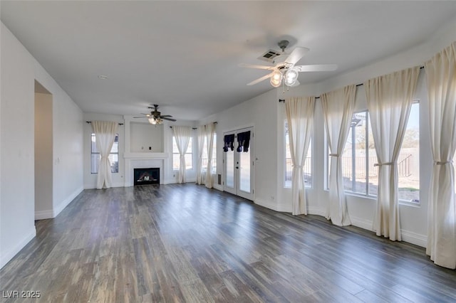 unfurnished living room featuring dark wood-type flooring and ceiling fan