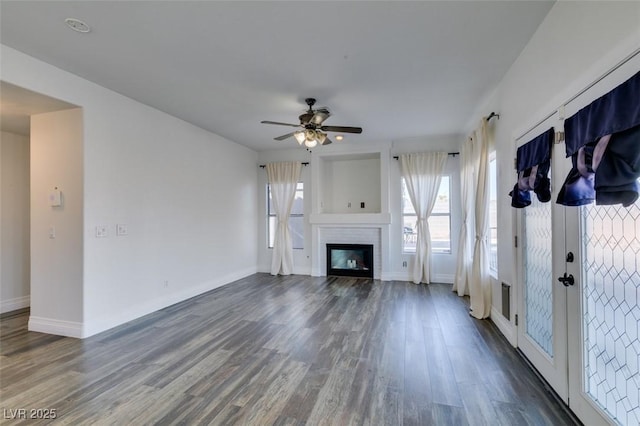 unfurnished living room featuring ceiling fan and dark hardwood / wood-style floors