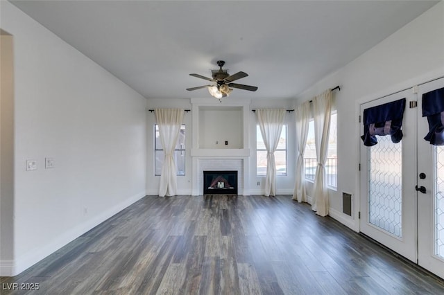 unfurnished living room with ceiling fan and dark hardwood / wood-style flooring