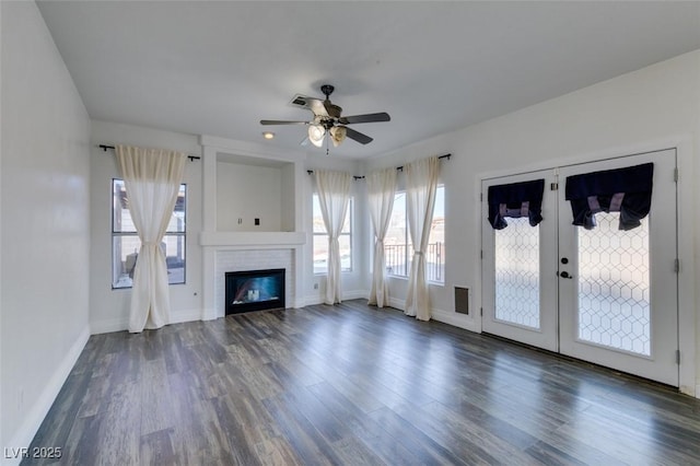 unfurnished living room featuring dark hardwood / wood-style floors, ceiling fan, and french doors