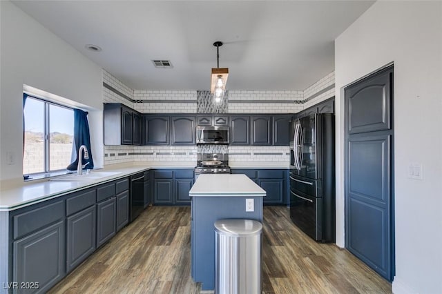 kitchen with a kitchen island, dark hardwood / wood-style floors, sink, hanging light fixtures, and black appliances