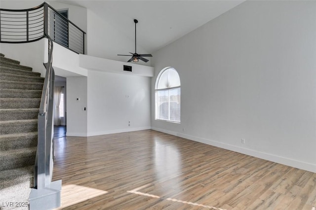 unfurnished living room featuring light hardwood / wood-style flooring, high vaulted ceiling, and ceiling fan