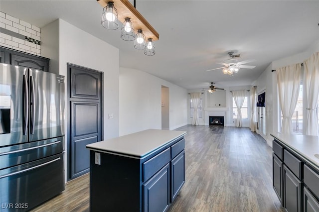 kitchen featuring blue cabinets, stainless steel refrigerator with ice dispenser, a center island, and light hardwood / wood-style floors