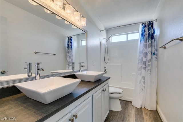 full bathroom featuring wood-type flooring, toilet, shower / bath combination with curtain, and vanity