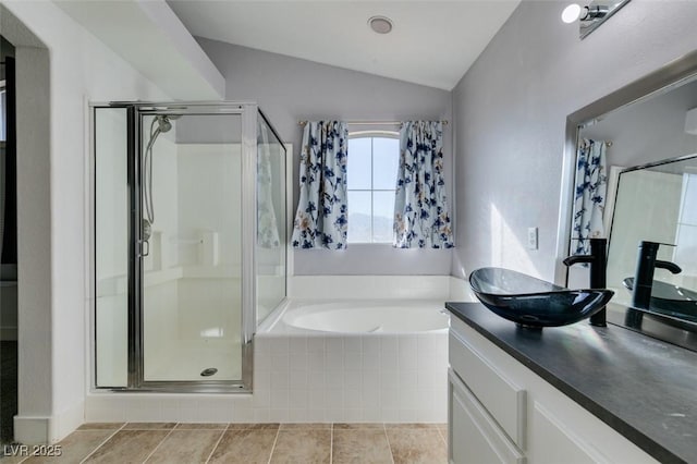 bathroom featuring vanity, plus walk in shower, tile patterned flooring, and vaulted ceiling