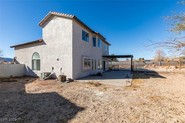 rear view of property featuring a pergola, cooling unit, and a patio area