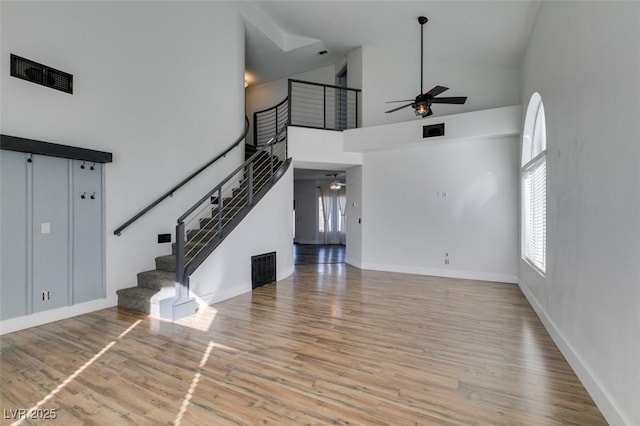 unfurnished living room featuring light hardwood / wood-style flooring, high vaulted ceiling, and ceiling fan