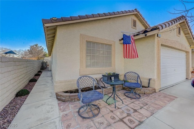 view of home's exterior featuring a garage and a patio