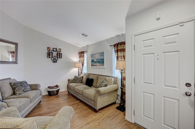 living room featuring vaulted ceiling and light wood-type flooring