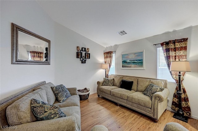 living room featuring lofted ceiling and light wood-type flooring