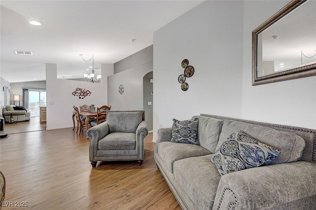 living room with an inviting chandelier and light hardwood / wood-style floors