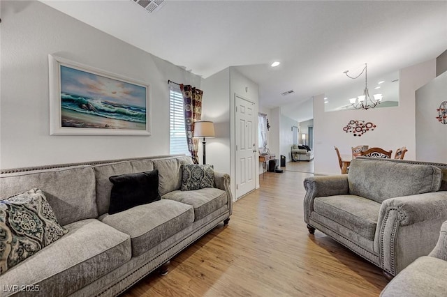 living room with an inviting chandelier and light hardwood / wood-style floors