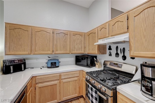 kitchen with light brown cabinetry and stainless steel range with gas cooktop