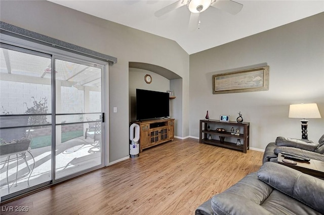 living room featuring ceiling fan, plenty of natural light, vaulted ceiling, and wood-type flooring